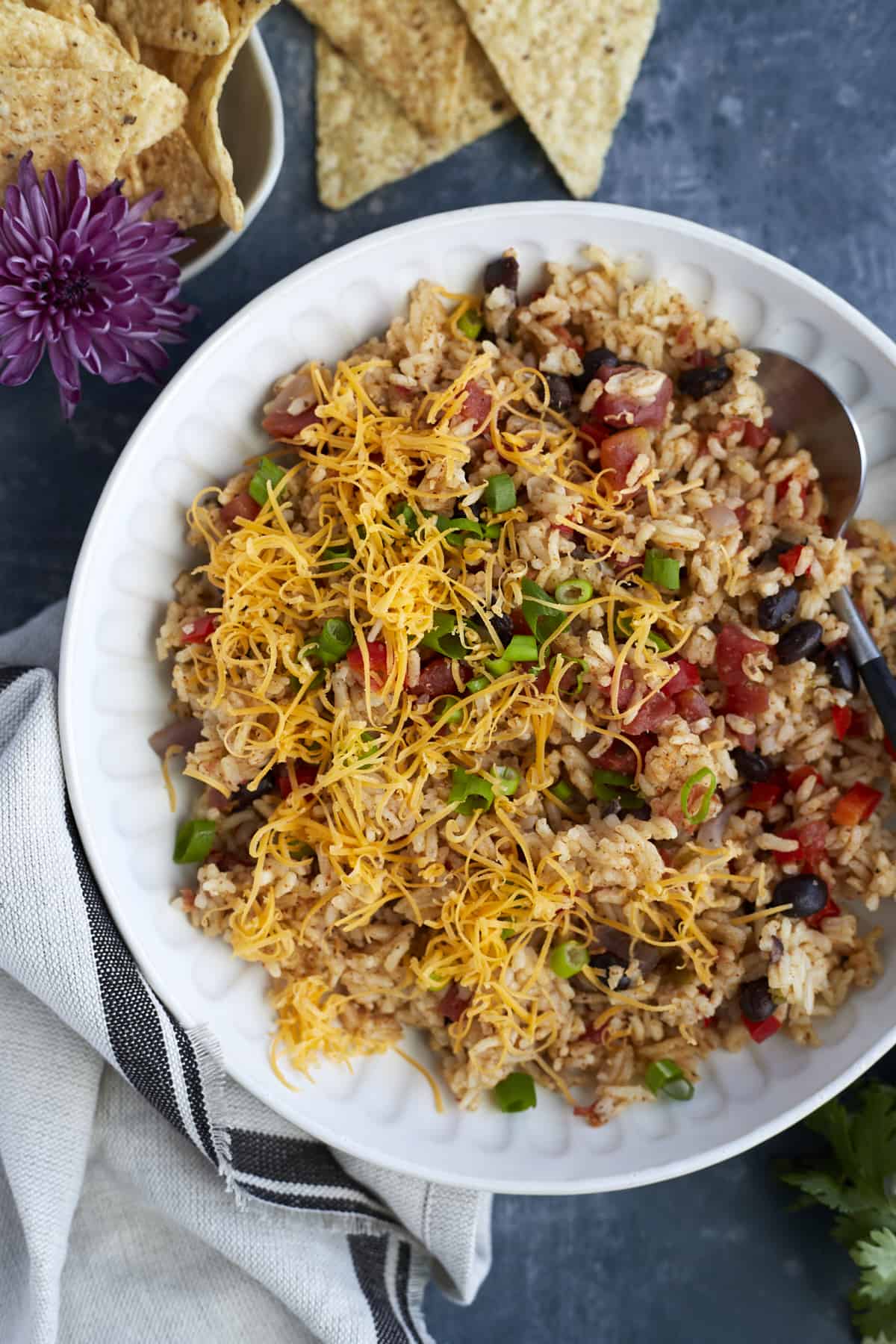 Overhead image of a white plate full of easy Mexican rice with cheese and veggies