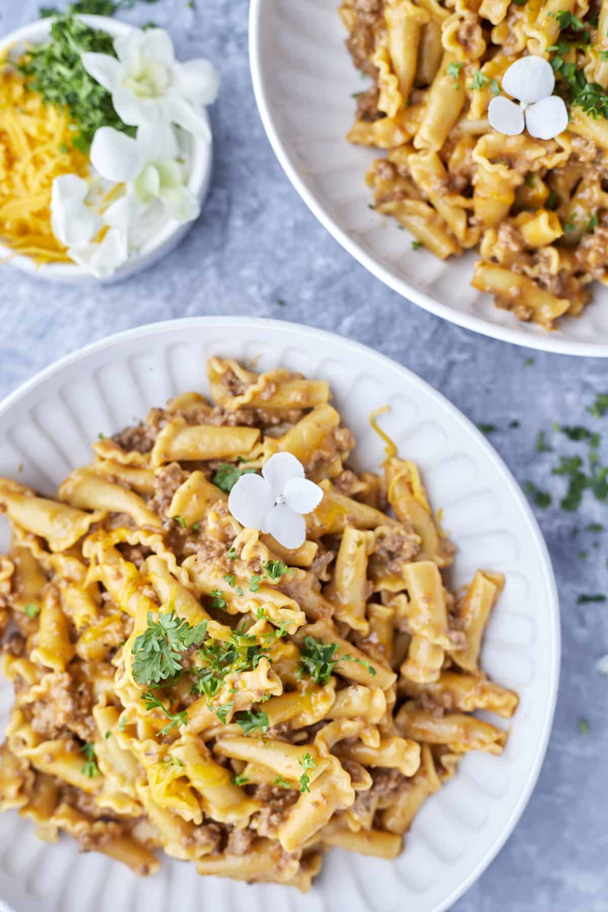 plated hamburger helper pasta on two plates garnished with Italian parsley.