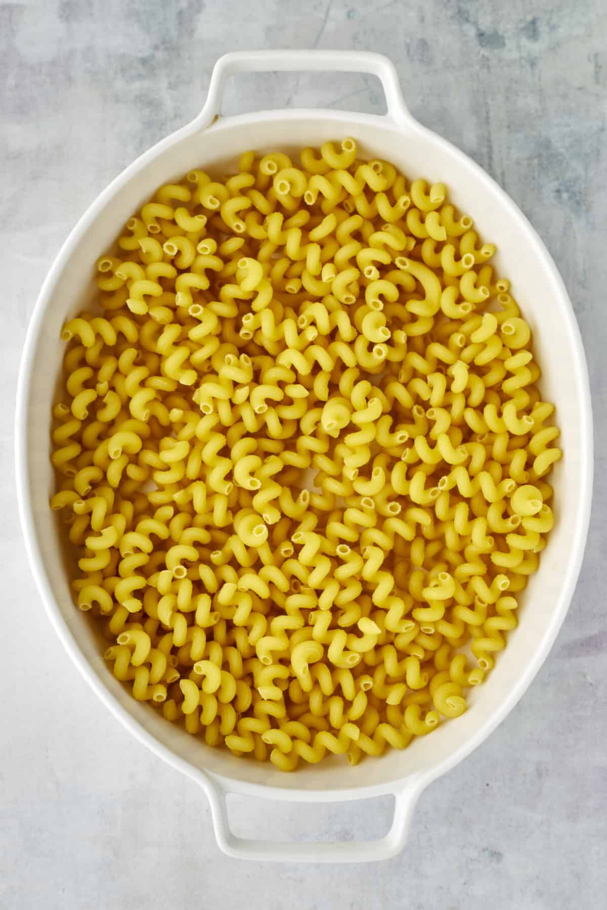 cavatappi noodles in an oval baking dish