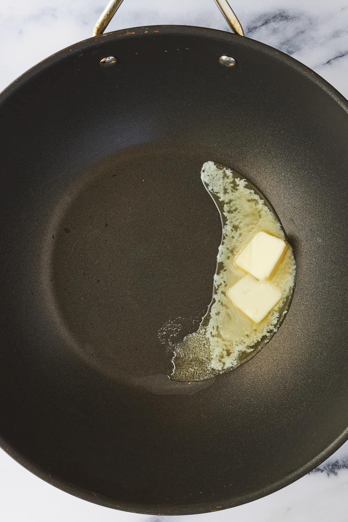 Butter melting in a wok. 