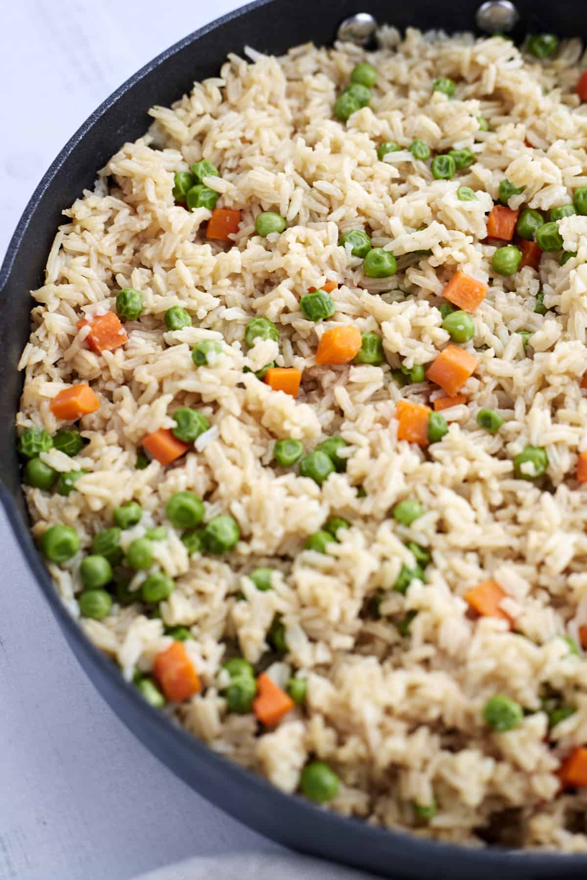 A skillet with cooked easy fried rice with veggies