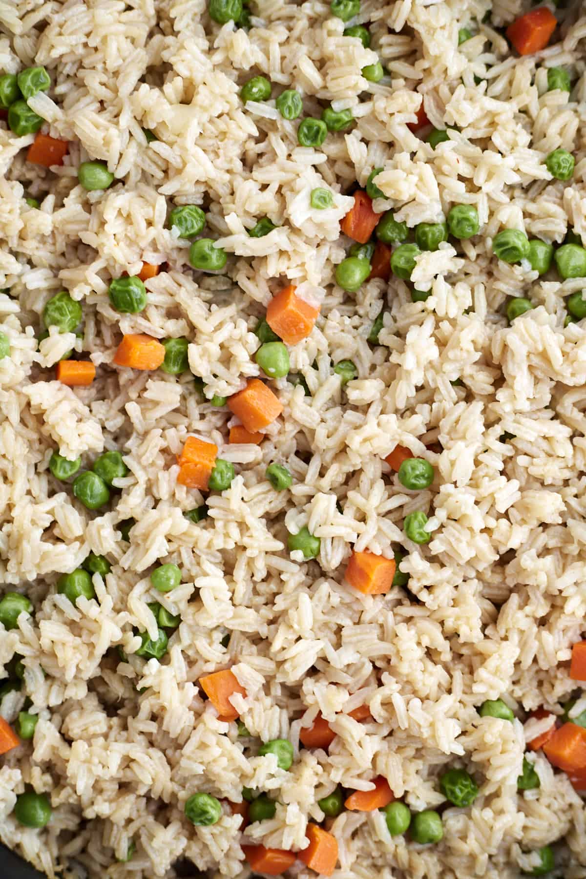 A close up image of easy fried rice with veggies including carrots and peas