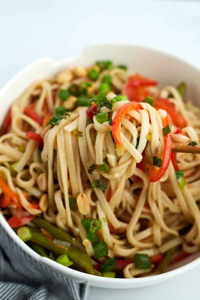 chopsticks scooping up a bite of vegetarian ramen from a bowl. 