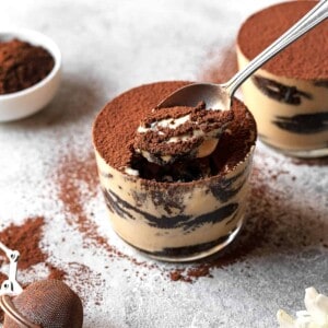 two jars of Oreo tiramisu with a spoon taking a scoop from one