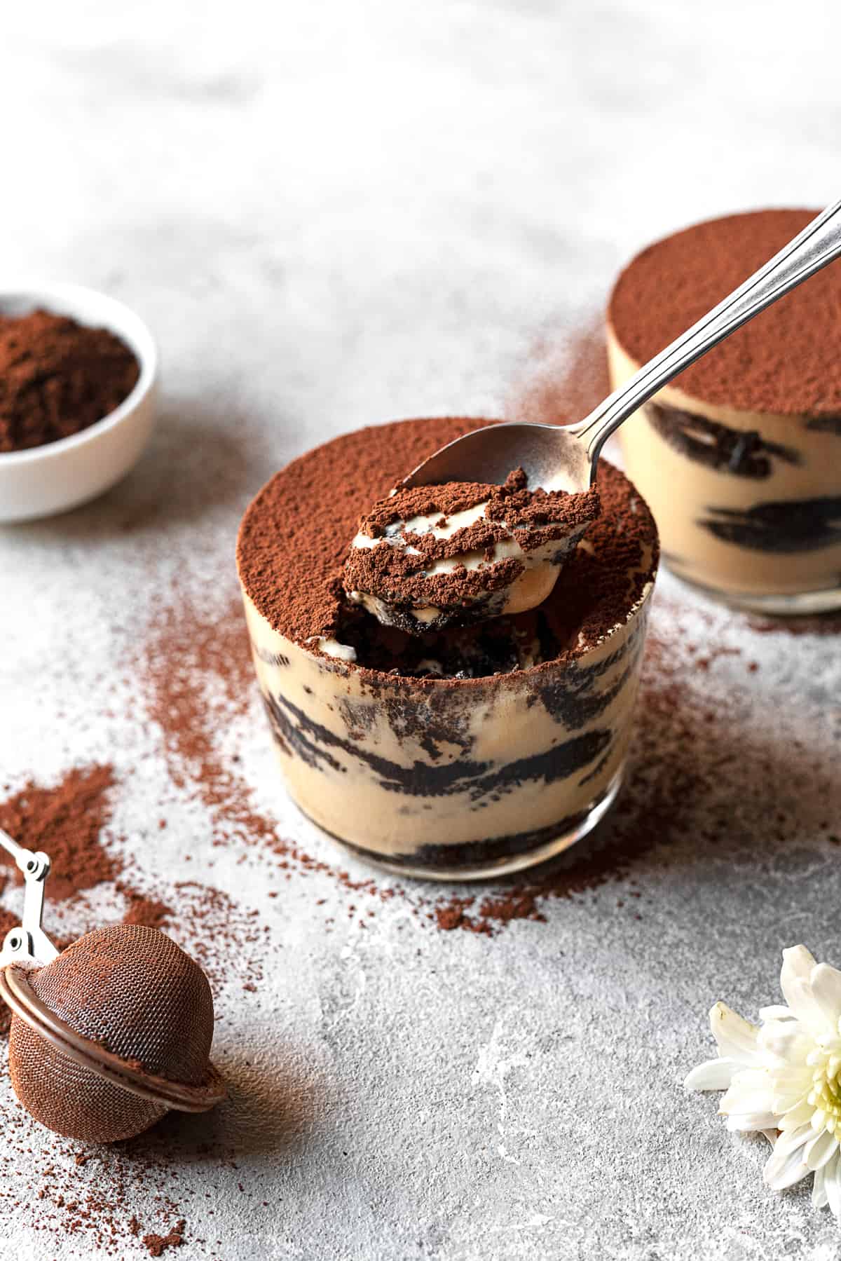 two jars of Oreo tiramisu with a spoon taking a scoop from one