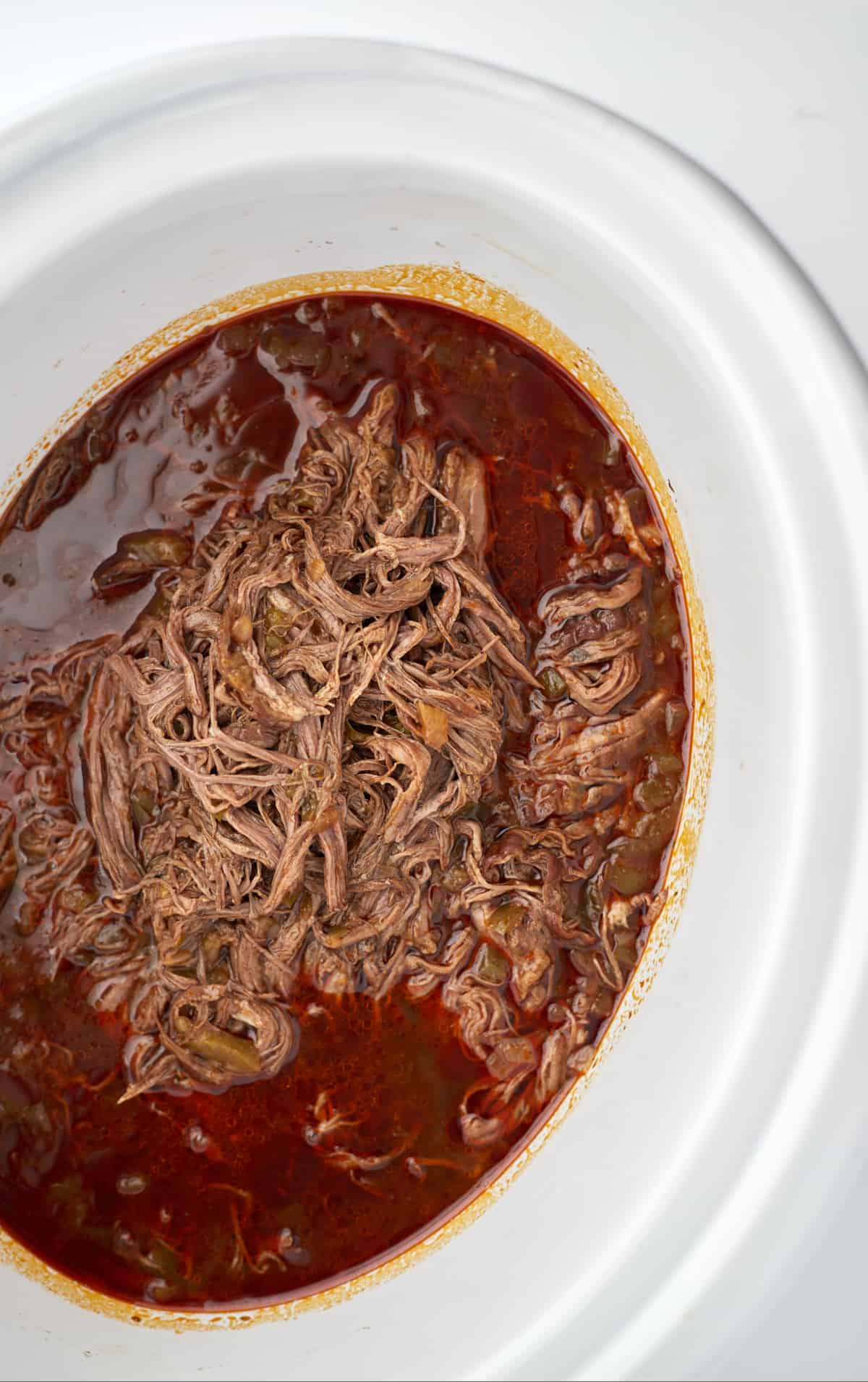 beef birria meat in a slow cooker
