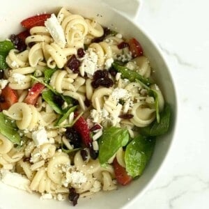 A bowl of summer pasta salad with fruit.