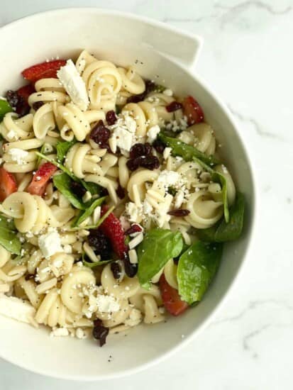 A bowl of summer pasta salad with fruit.