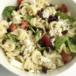 A bowl of summer pasta salad with fruit.