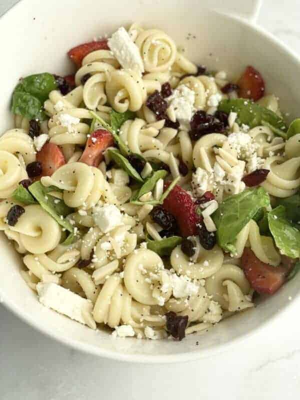A bowl of summer pasta salad with fruit.