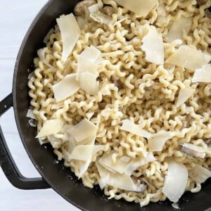 a pot full of mushroom stroganoff with fusilli pasta topped with shaved Parmesan