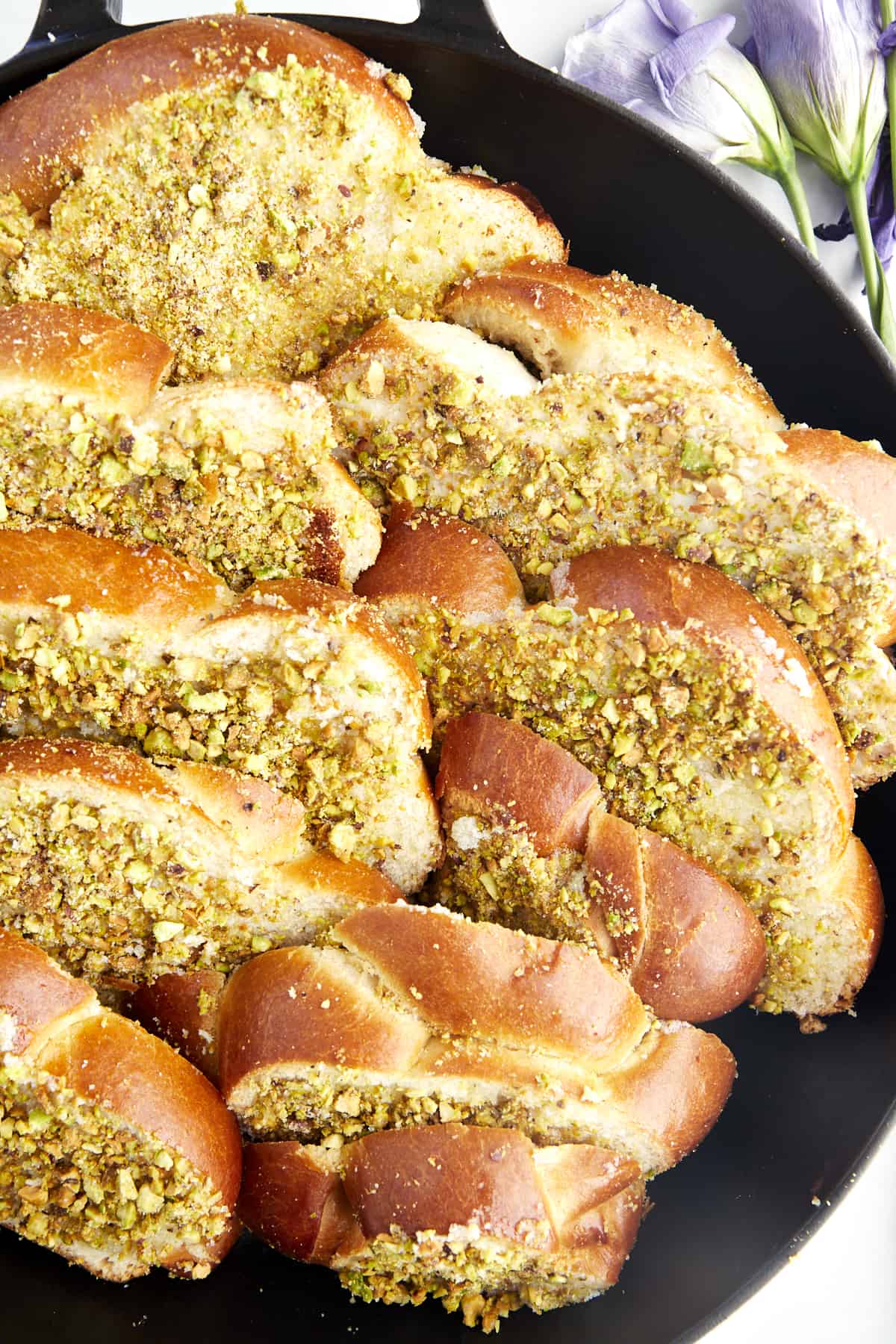 Raw slices of Brioche bread in a skillet with baklava coating to make Baklava French toast. 