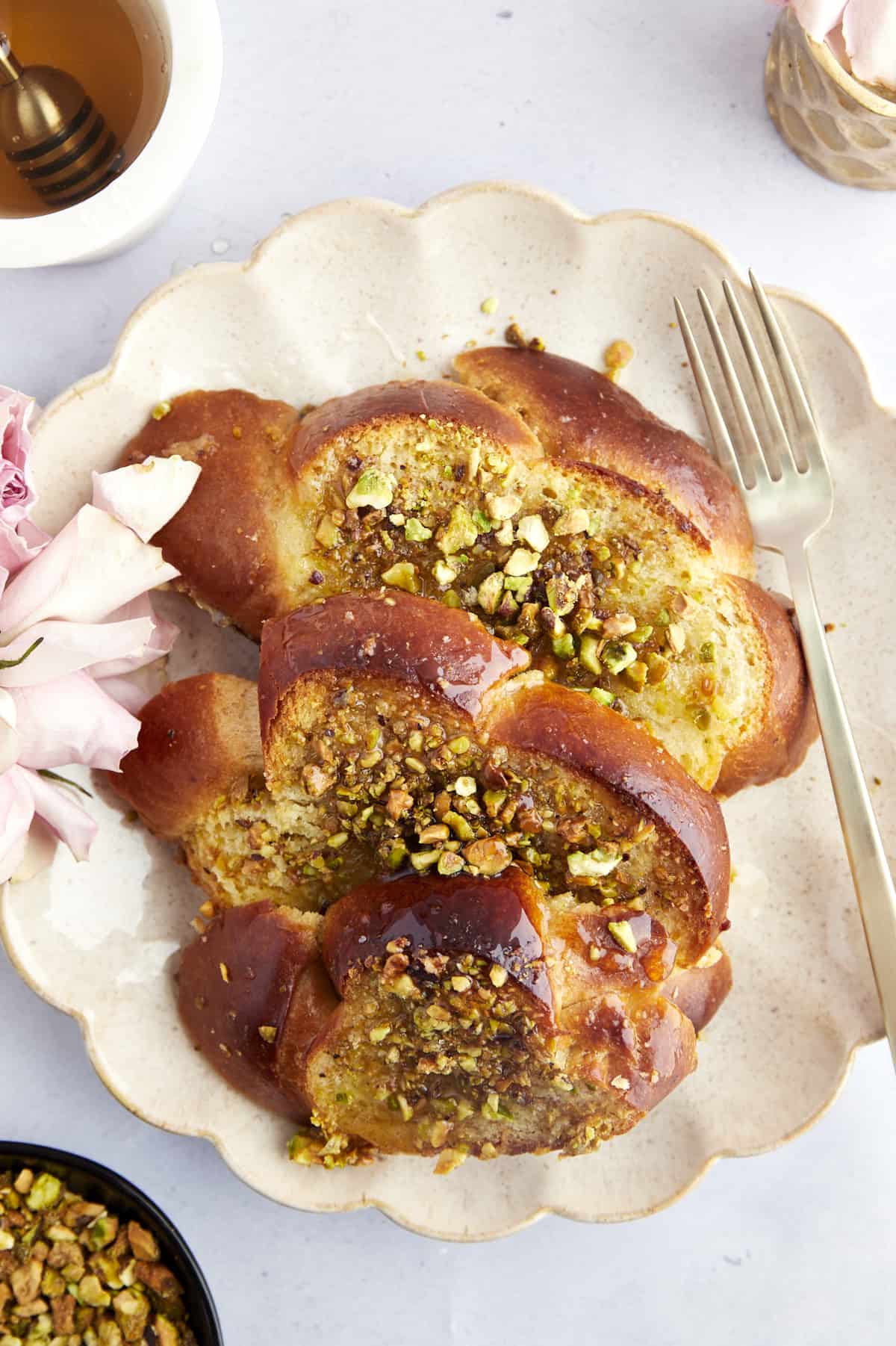 Three pieces of  Baklava French toast on a plate topped with syrup with a fork on the side. 