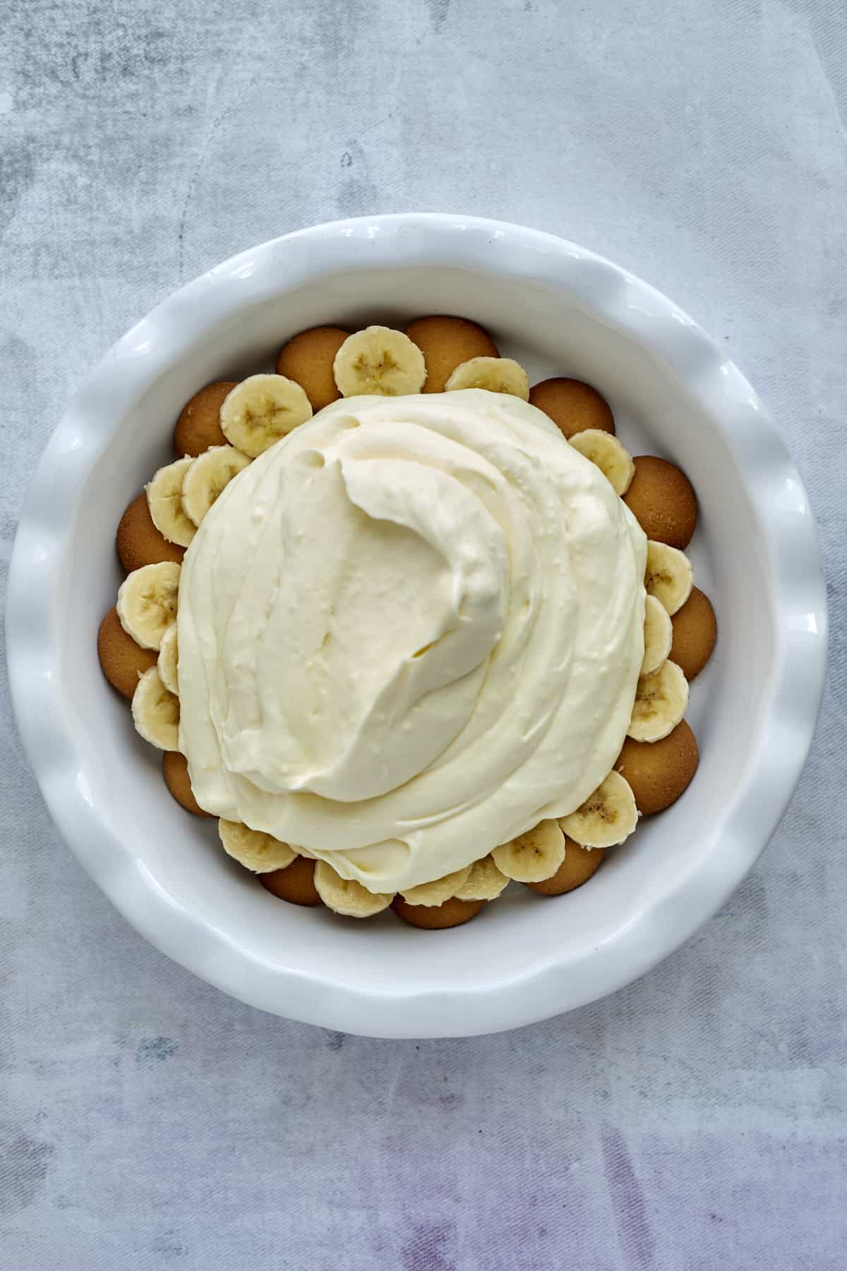 Nilla wafers topped with banana slices and vanilla pudding filling in a baking dish