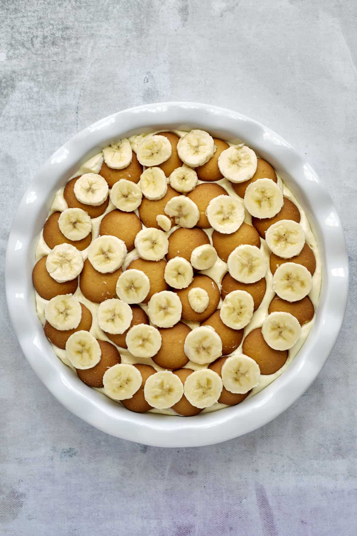 Nilla wafers and banana coins over vanilla pudding for banana pudding