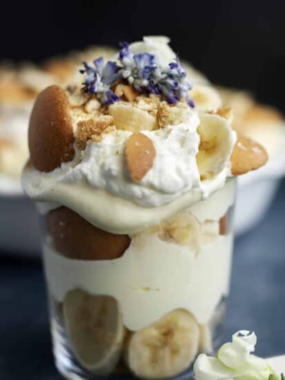 a jar of banana pudding topped with whipped cream, Nilla wafers, and banana coins.
