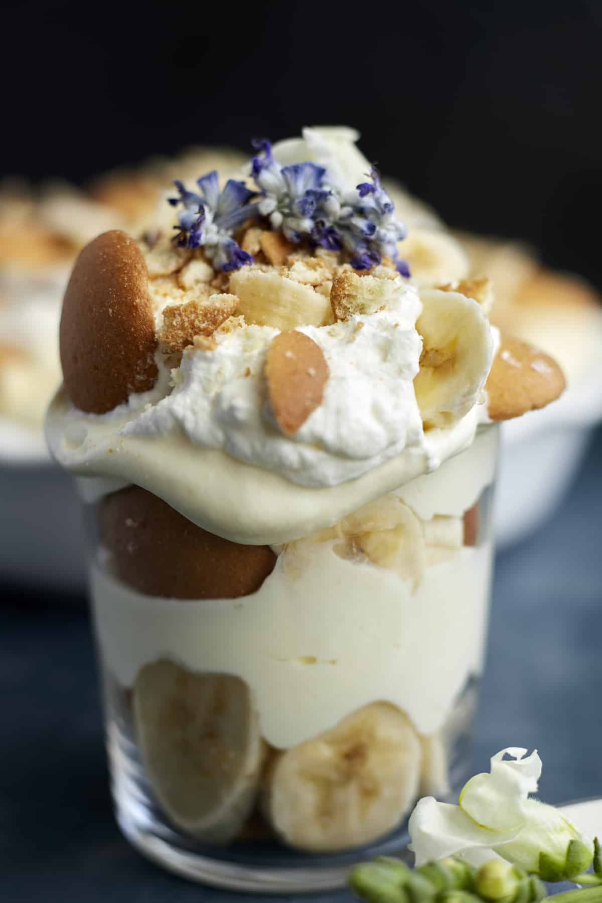 a jar of copycat Magnolia Bakery banana pudding topped with whipped cream, Nilla wafers, and sliced bananas