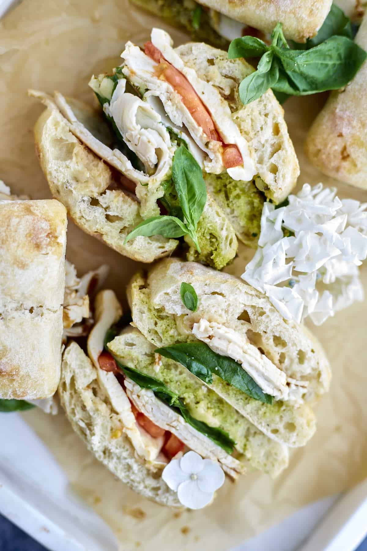 overhead image of a turkey caprese sandwich sliced in half.