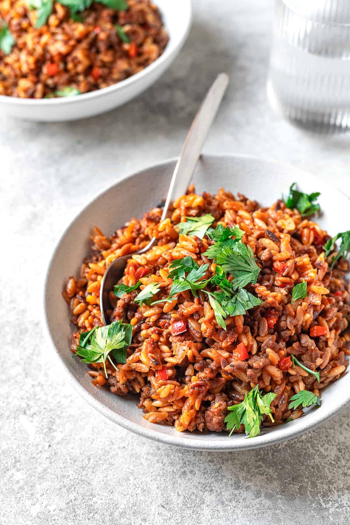 egyptian orzo pasta on a plate with parsley and serving spoon