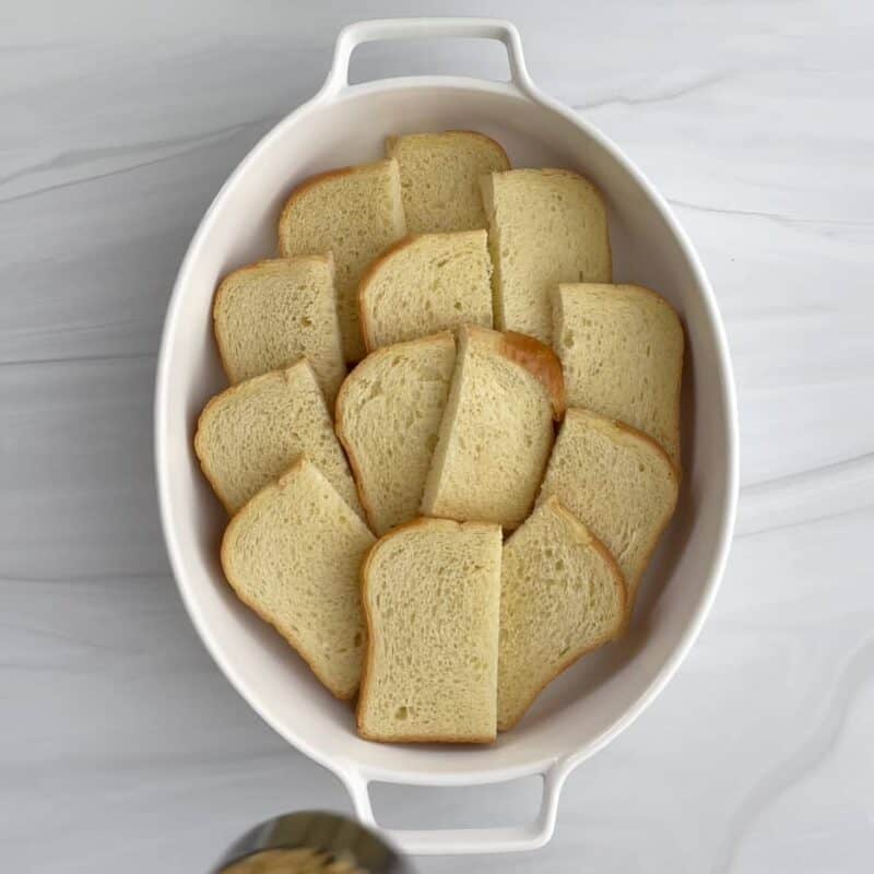 overhead image of pieces of brioche bread in a white baking dish