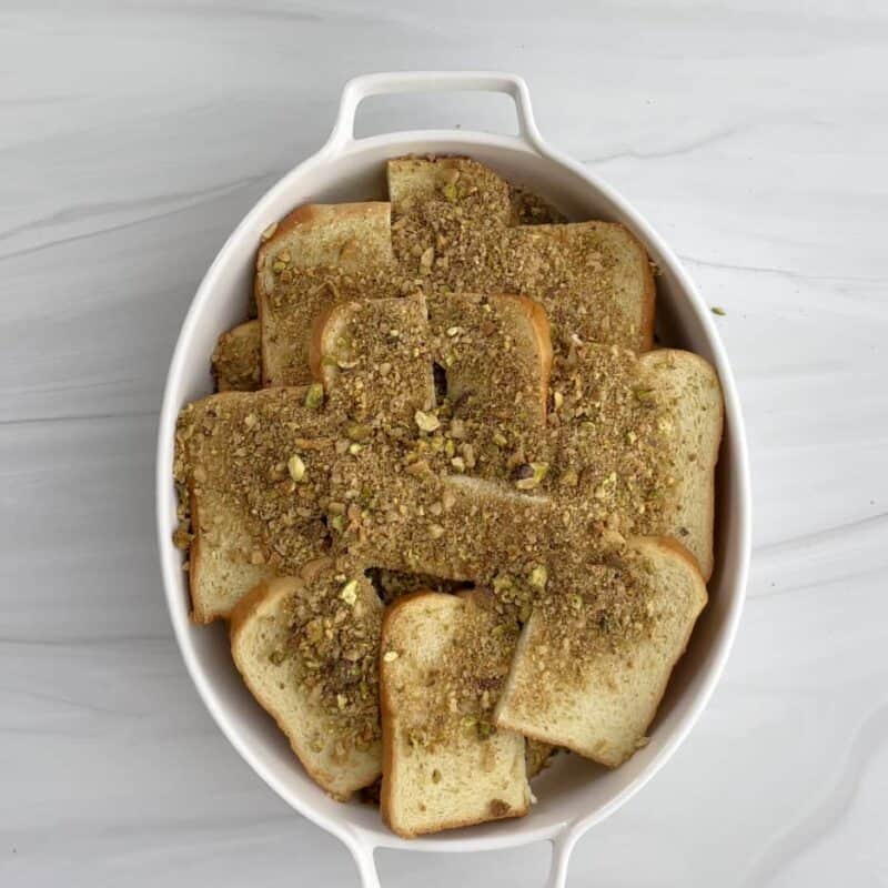 unbaked baklava brioche french toast in a white baking dish