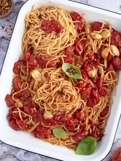 a baking dish full of easy one pan spaghetti with roasted tomatoes, garlic, and onions