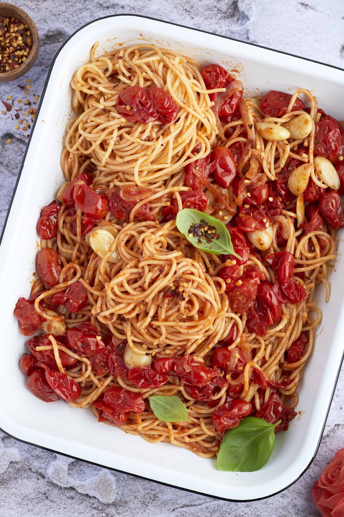 overhead image of a baking dish full of one pan spaghetti with roasted tomatoes and garlic