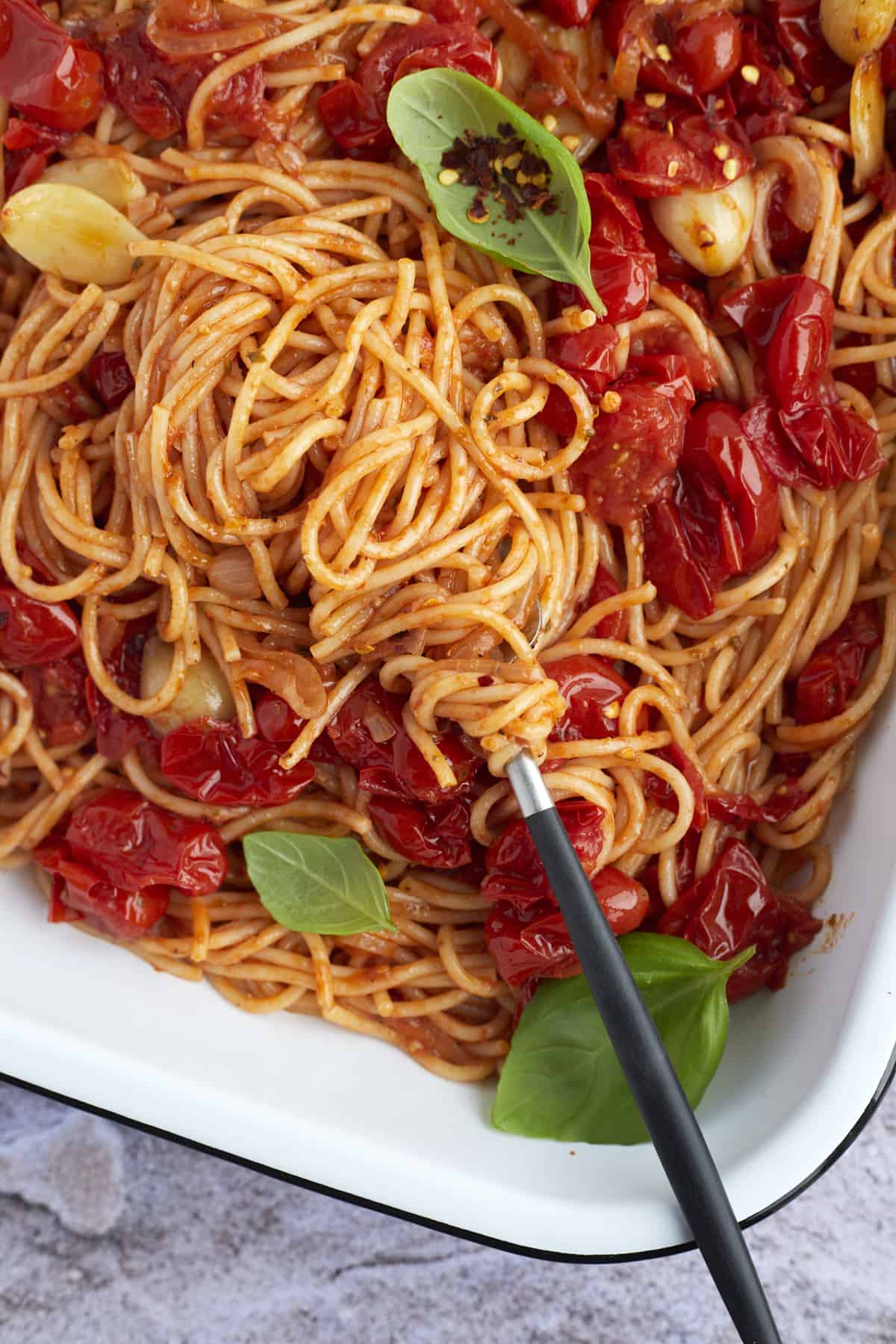 easy one pan spaghetti in a baking dish being swirled with a fork