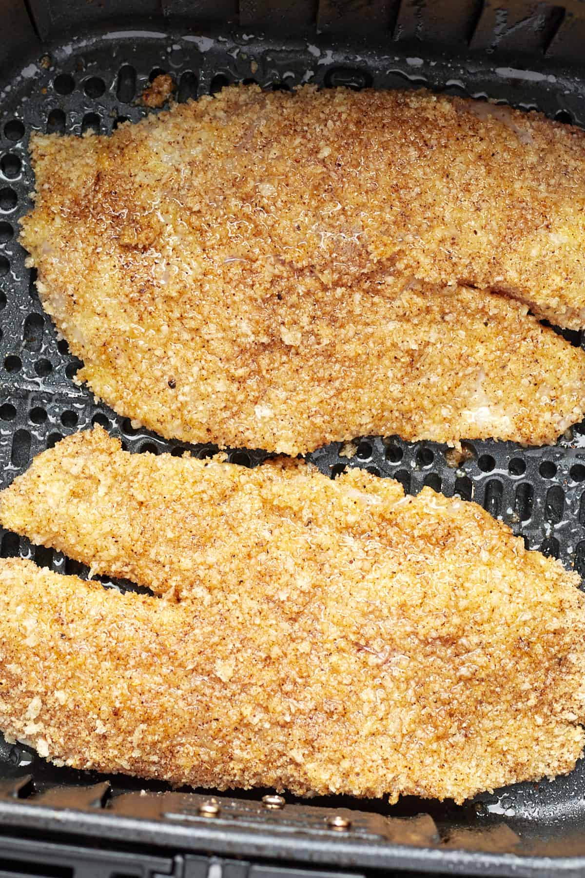 air fried tilapia in the basket of an air fryer