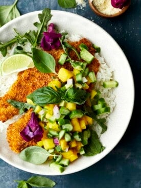 A bowl of coconut rice with air fried tilapia and mango salsa.