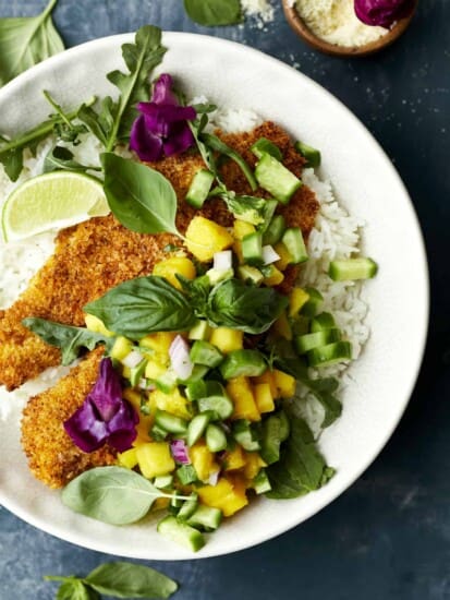 A bowl of coconut rice with air fried tilapia and mango salsa.