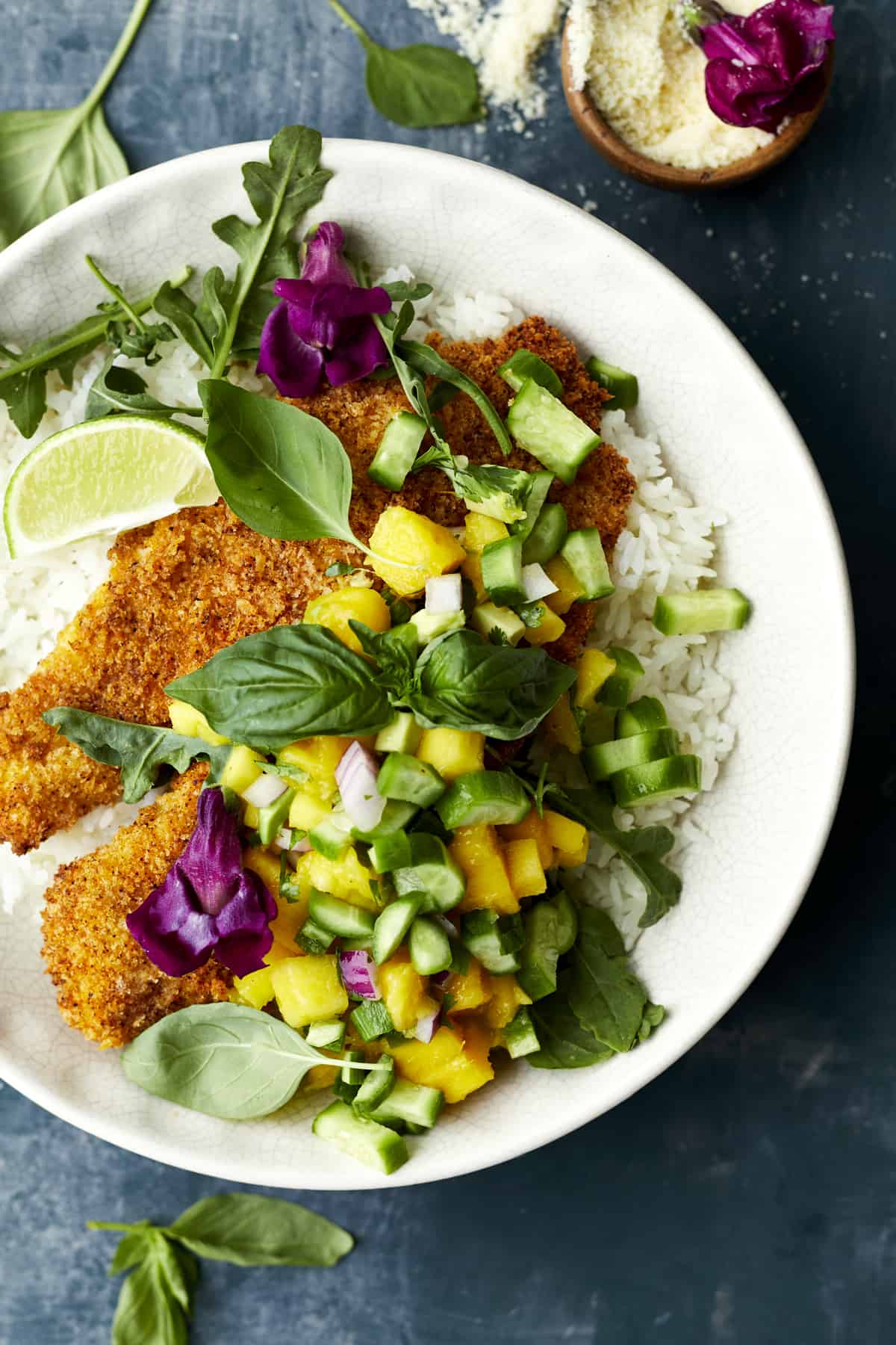 A bowl of coconut rice with air fried tilapia and mango salsa.