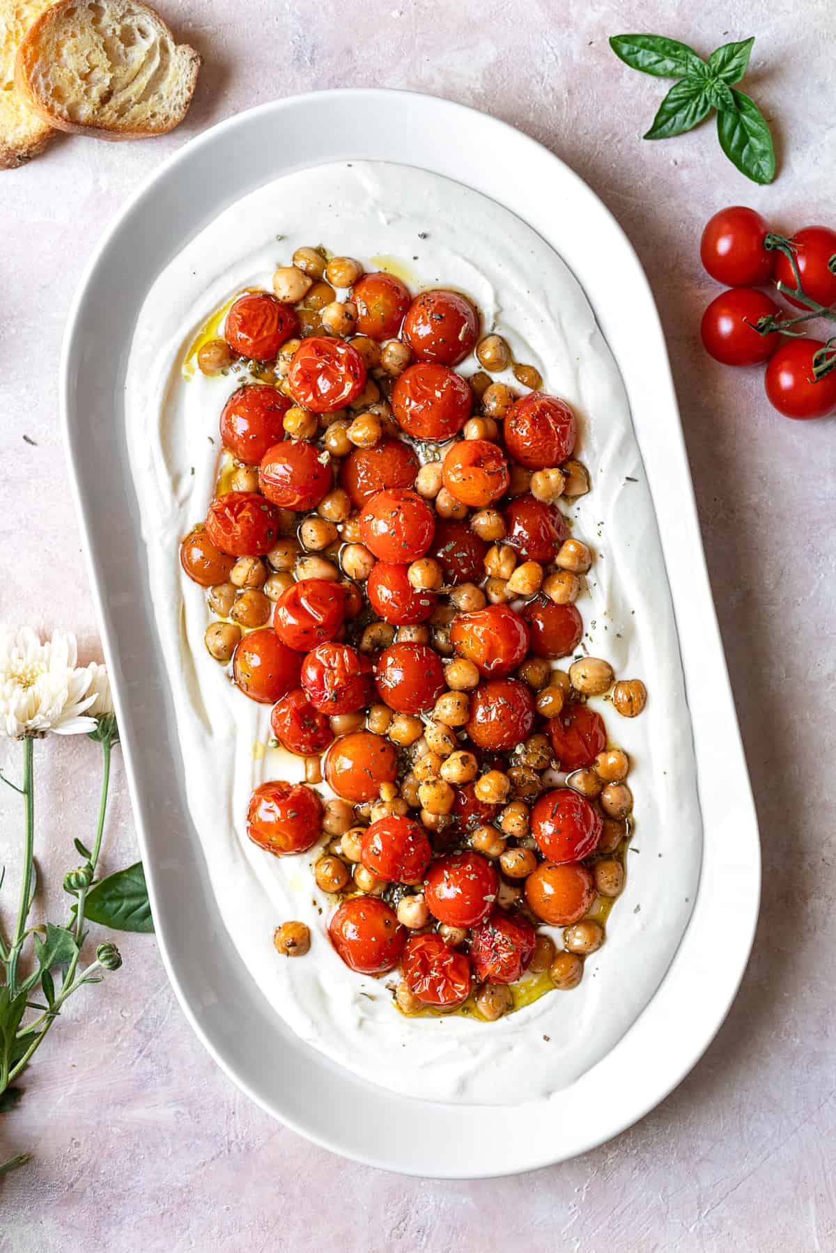 large oval platter with whipped feta topped with roasted tomatoes and chickpeas