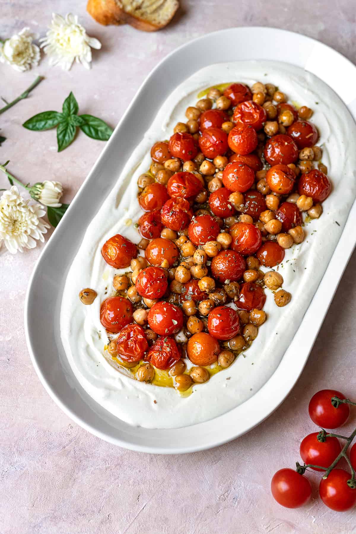 side view of large oval platter with whipped feta and topped with roasted tomatoes and chickpeas
