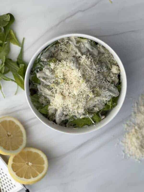 A bowl of lemon ricotta pasta made with spinach and olive leaf pasta topped with grated Parmesan