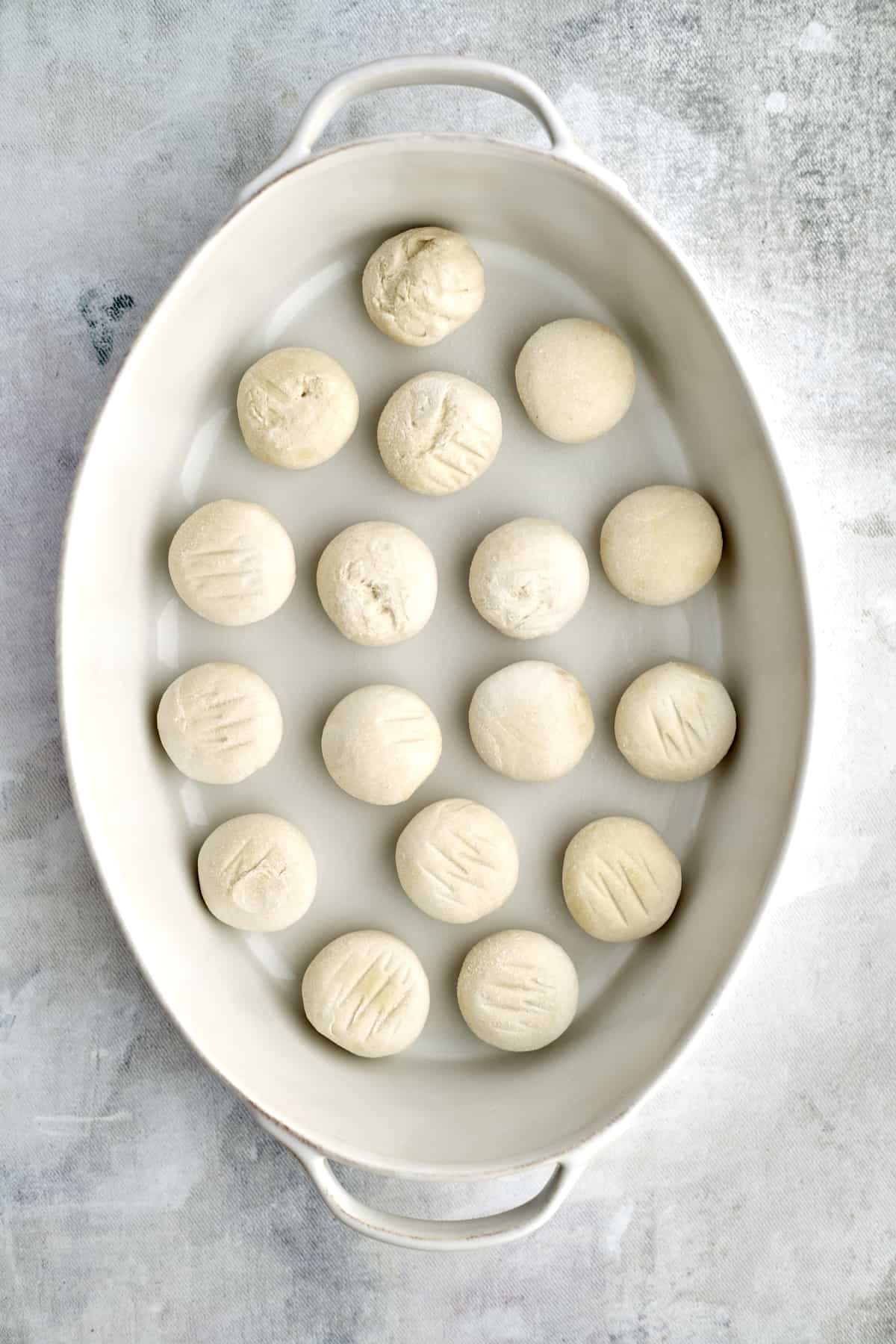 raw bread roll dough in a baking dish 