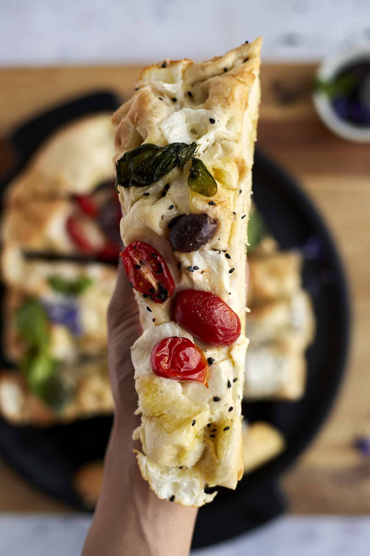 close up image of a slice of no knead focaccia bread art