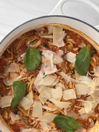 overhead image of one pot healthy spaghetti topped with Parmesan flakes and herbs