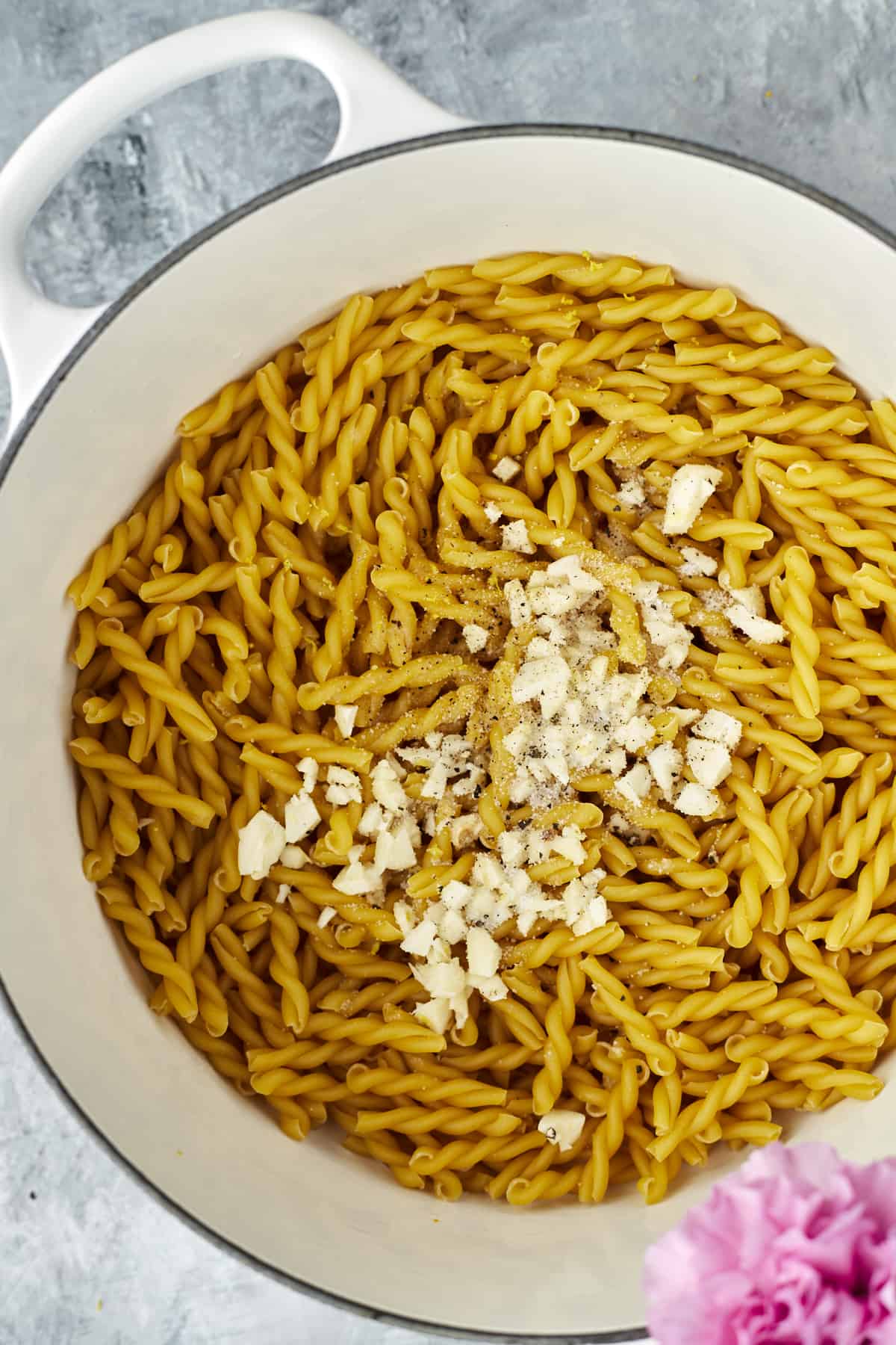 pot full of uncooked pasta noodles topped with Parmesan