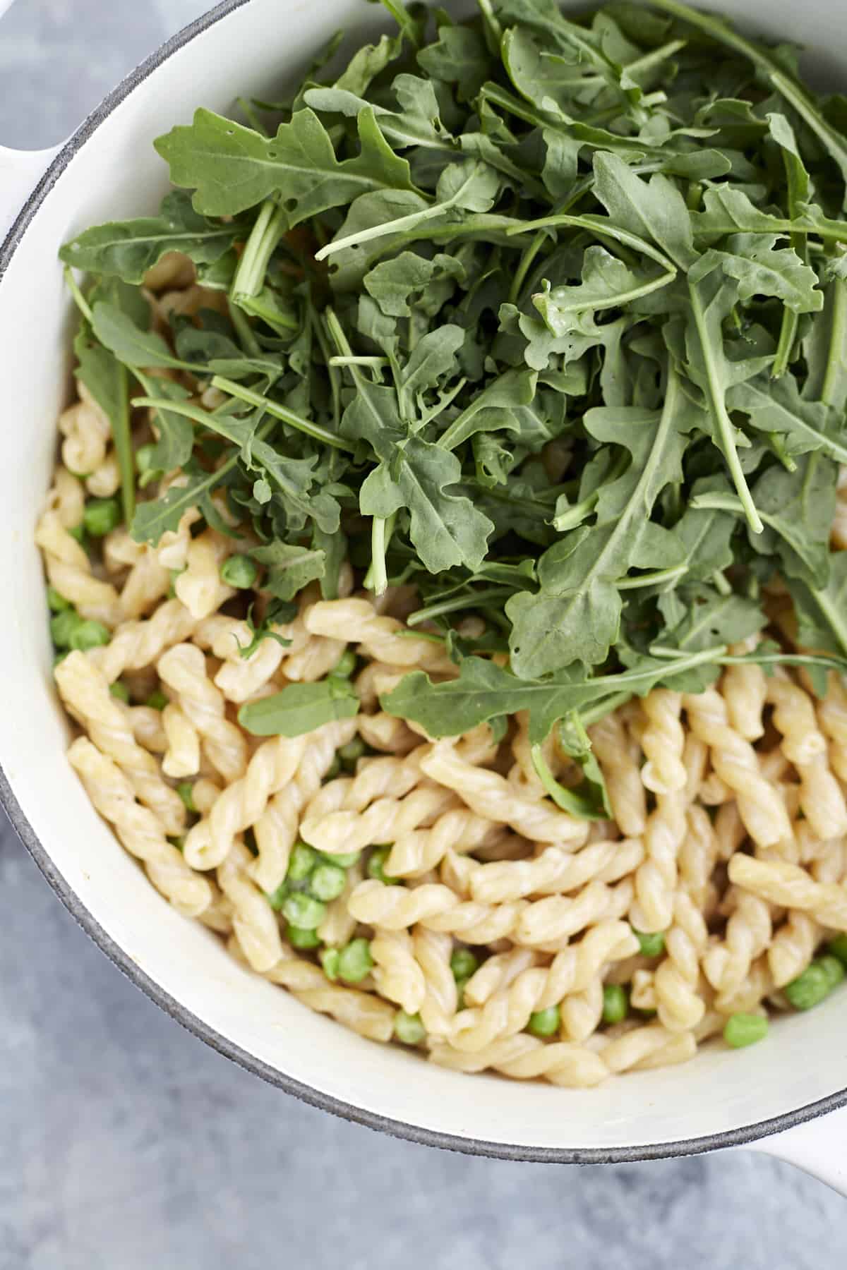 lemon pasta in a pot with arugula and peas