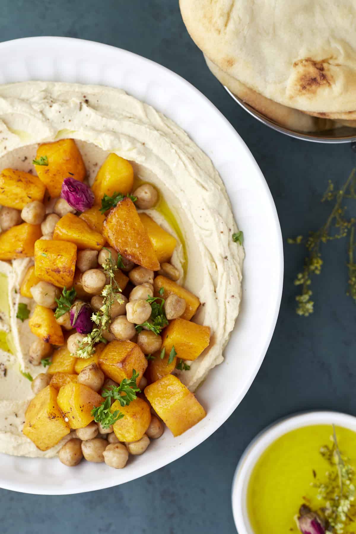 a bowl of roasted maple butternut squash hummus dip topped with roasted chickpeas and butternut squash
