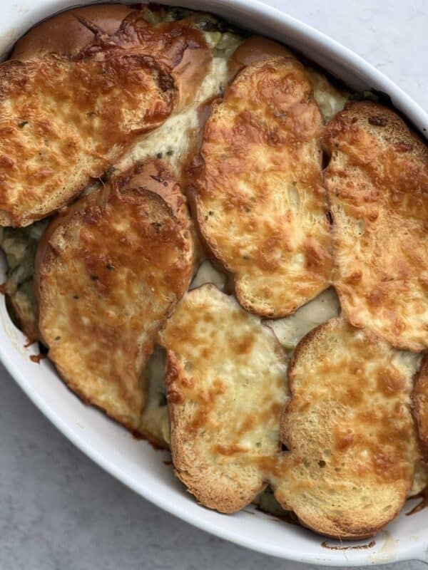 overhead image of Spinach and Artichoke Grilled Cheese Sandwiches in a white baking dish