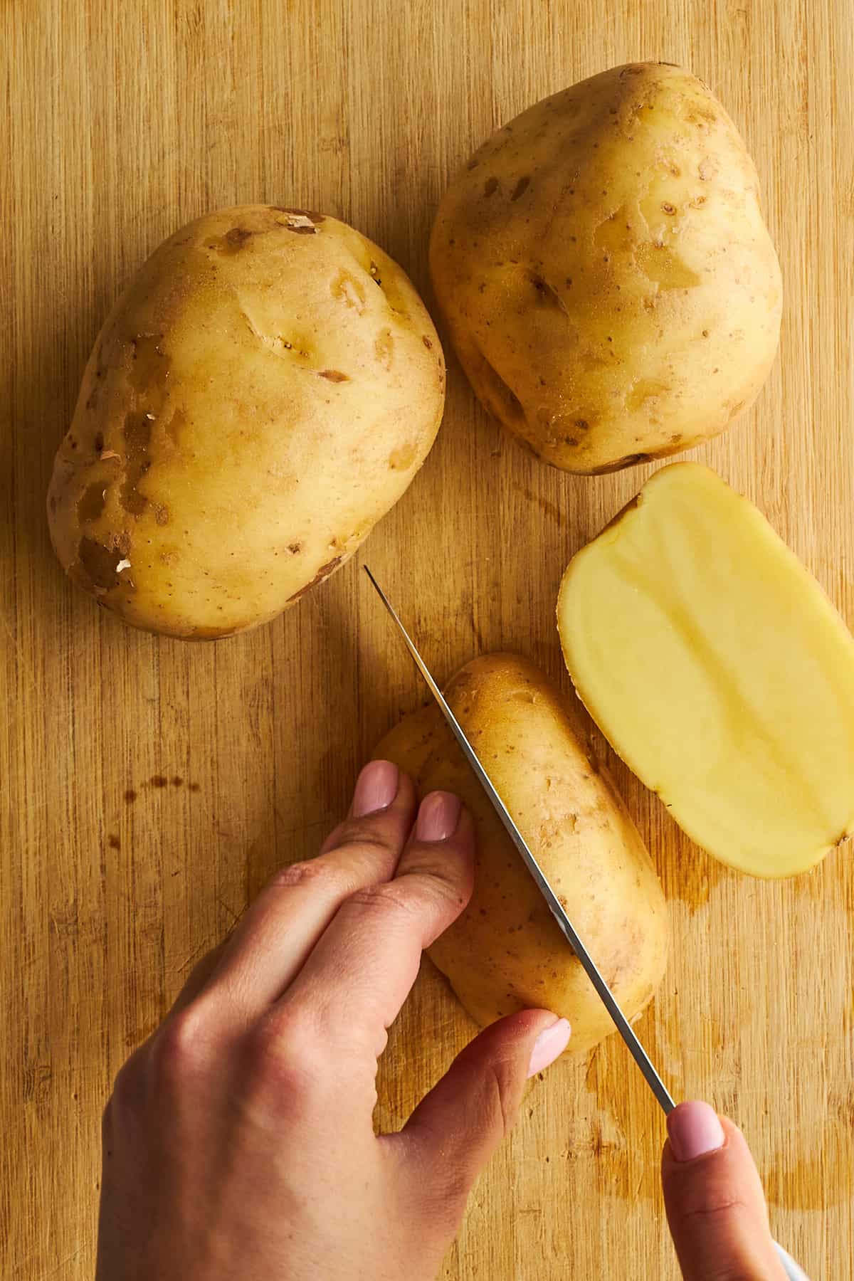 Potatoes being sliced into wedges. 