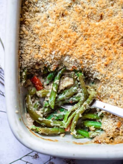 A dish of green bean casserole with a scoop missing.