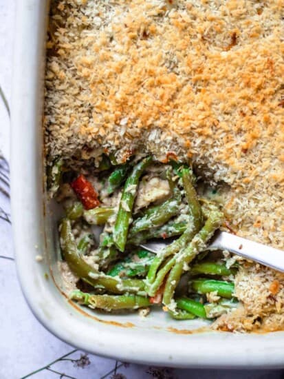 A dish of green bean casserole with a scoop missing.