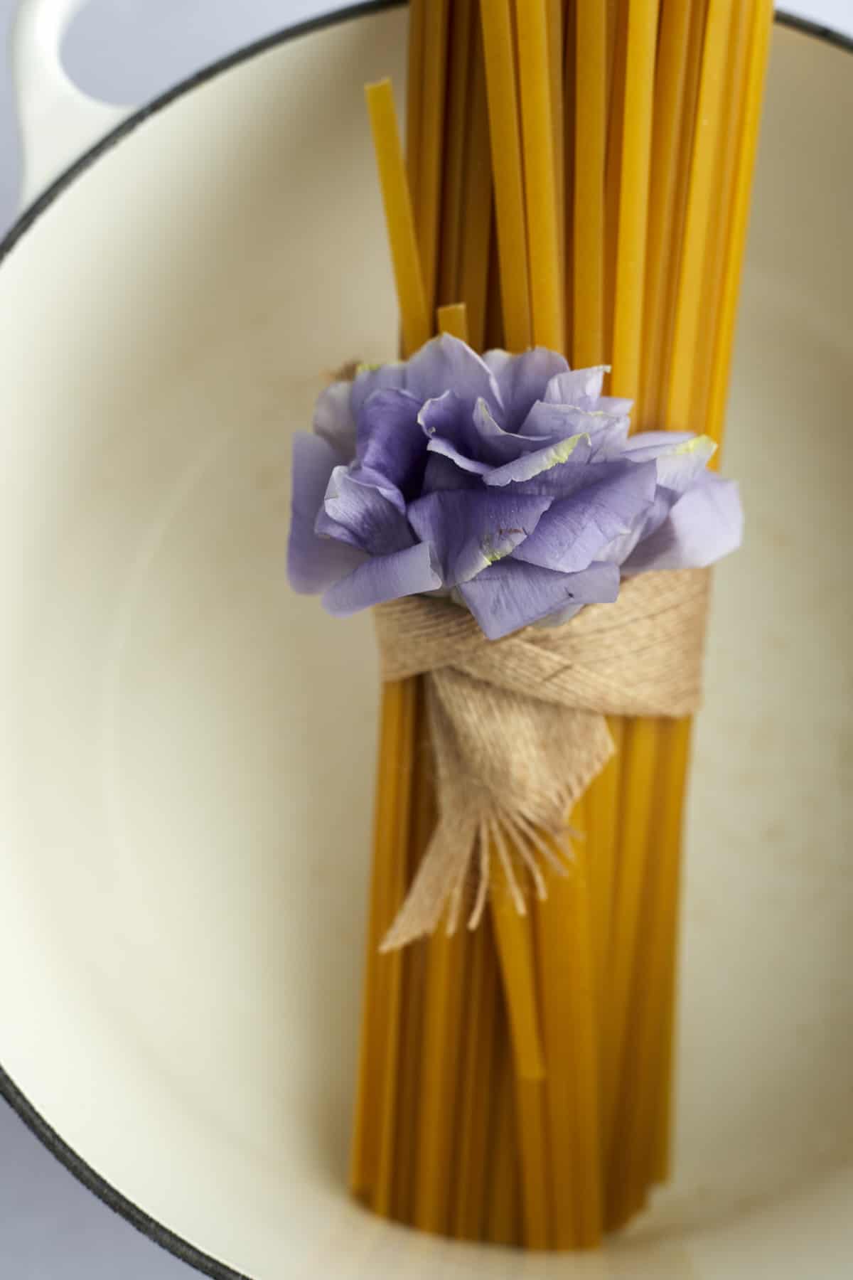 A bundle of fettuccine noodles in a pot. 