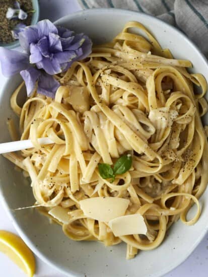A bowl of one pot fettuccine alfredo with a fork twirled around a bite.