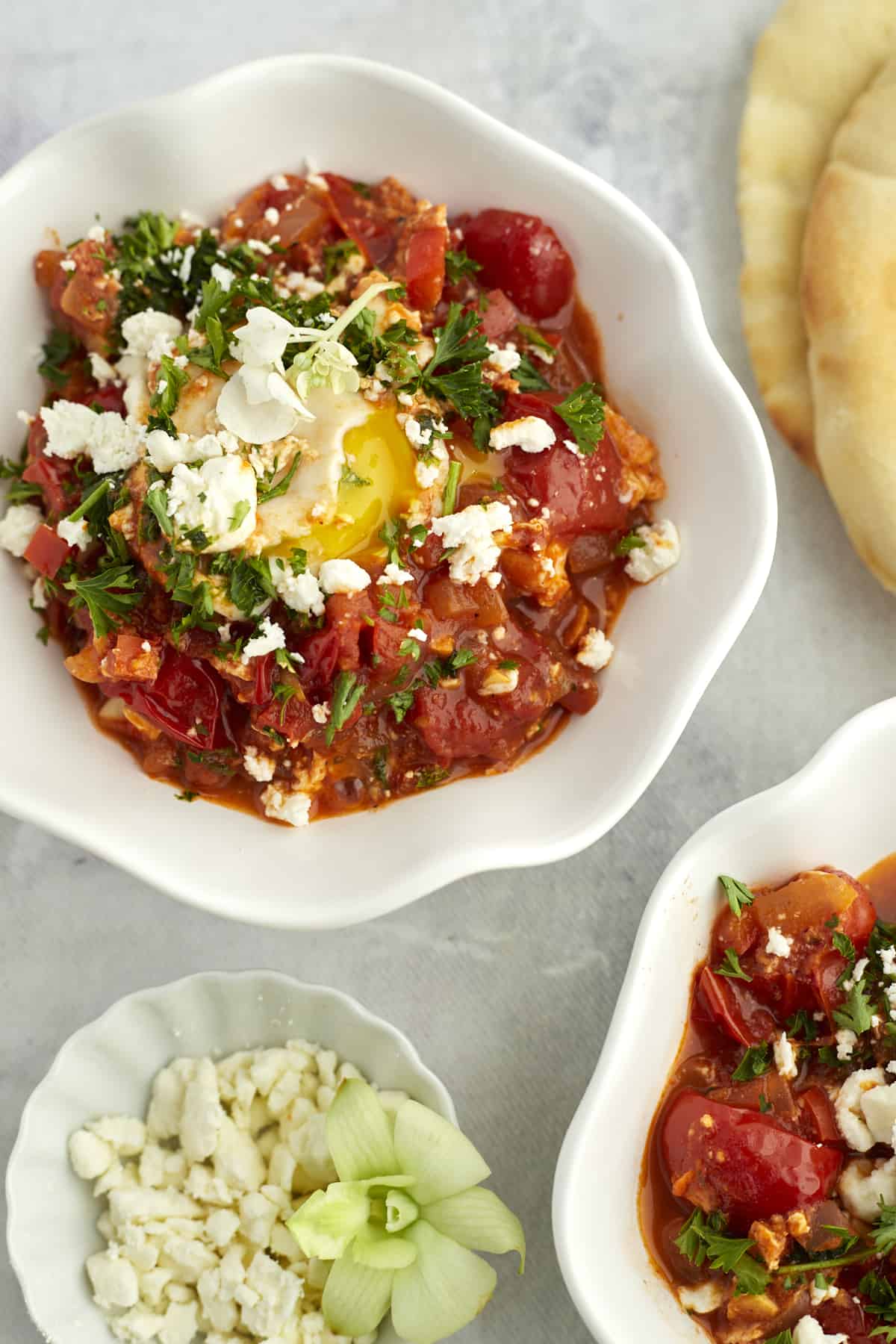 two white bowls full of easy shakshuka with feta