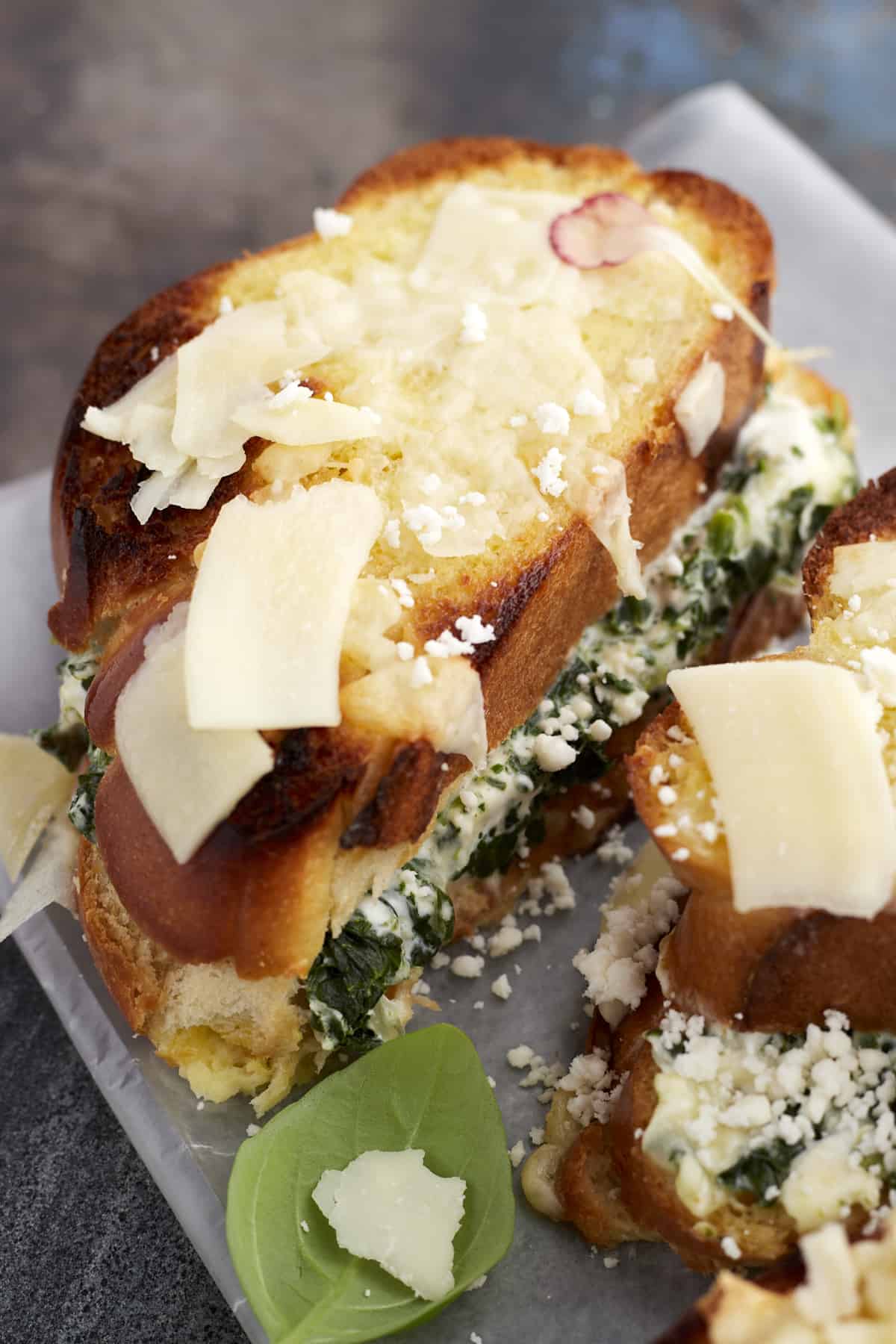 close up image of a sliced spanakopita-inspired spinach grilled cheese