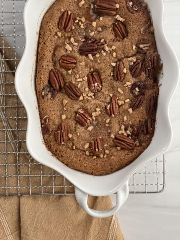 pecan pie cobbler in a white baking dish on top of a cooling rack